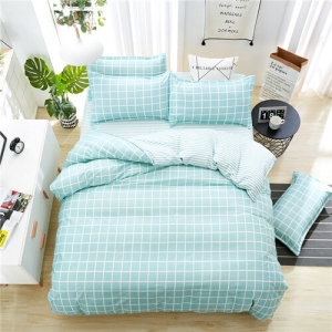 Parure de lit bleu clair à motifs carreaux blancs. Bonne qualité, confortable et à la mode sur un lit dans une maison