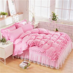 Parure de lit rose à dentelle. Bonne qualité, confortable et à la mode sur un lit dans une maison