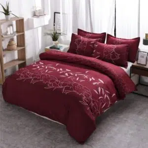 Parure de lit bordeaux à motif floral unique. Bonne qualité, confortable et à la mode sur un lit dans une maison