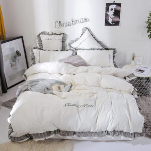 Parure de lit blanche contour gris. Bonne qualité, confortable et à la mode sur un lit dans une maison
