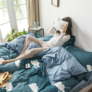 Parure de lit vert foncé avec imprimé nuages. Bonne qualité, confortable et à la mode sur un lit dans une maison