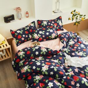 Parure de lit bleu marine avec imprimé fraise et fleurs. Bonne qualité, confortable et à la mode sur un lit dans une maison