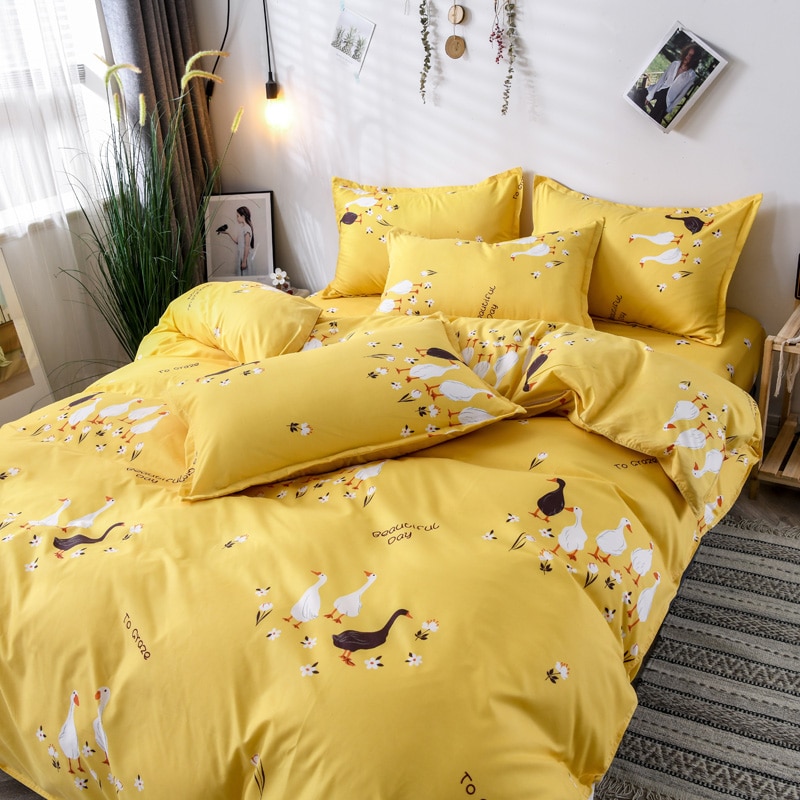 Parure de lit jaune avec imprimés oie. Bonne qualité, confortable et à la mode sur un lit dans une maison