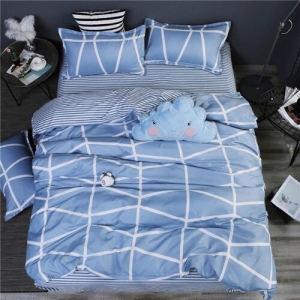 Parure de lit bleu à motifs géométriques blancs. Bonne qualité, confortable et à la mode sur un lit dans une maison
