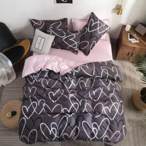 Parure de lit grise à motif cœurs blanc et noir. Bonne qualité, confortable et à la mode sur un lit dans une maison