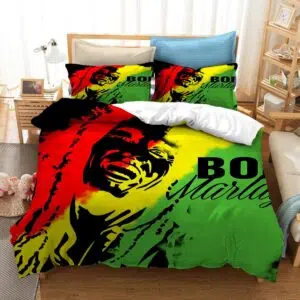 Dans une chambre le lit est décoré d'une parure à l'effigie de Bob Marley, de couleur rouge, jaune et vert, avec l'ombre du visage de bob marley en noir, les coussins sont assortis, à droite du lit il y a un banquette en bois avec les coussins blanc, et un meuble étagère en bois, à gauche du lit il y a une table de chevet en bois et des jouets