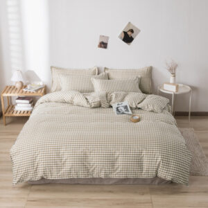 Parure de lit de couleur beige et blanche à carreau, dans une chambre au style scandinave avec parquet et mur blanc
