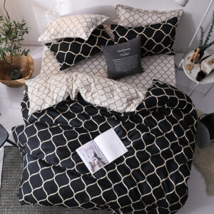 Parure de lit scandinave avec motif de nid d'abeille en noir et blanc avec un livre ouvert posé dessus