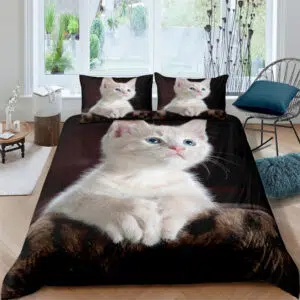 Parure de lit représentant un chat aux yeux bleus et pelage blanc posé sur un fond sombre dans une chambre avec parquet et mur blanc