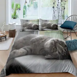 Parure de lit représentant un chat au pelage gris couché sur le dos sur un drap blanc