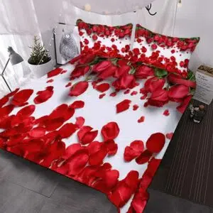 Parure de lit romantique blanches avec des pétales de roses rouges dans une chambre aux tons blanc et gris