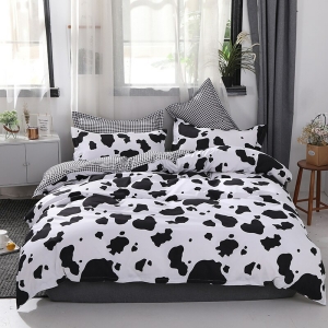 Parure de lit moderne de couleur noir et blanc, au motif vache dans une chambre au style nordique au ton clair