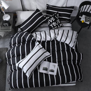 Parure de lit moderne de couleur noire et aux rayures blanches dans une chambre au sol gris