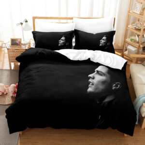 Parure de lit noire avec la photo en noir et blanc de cristiano ronaldo, dans une chambre avec une table de chevet en bois à gauche et un meuble étagère à gauche