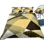 Parure de lit scandinave jaune et noire installée sur un lit et près d'une chaise assortie
