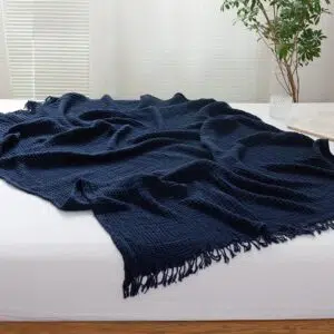 Couvre-lit bleu foncé en gaze de coton avec un fond une chambre