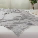Couvre-lit gris clair en gaze de coton avec un fond une chambre