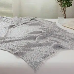 Couvre-lit gris clair en gaze de coton avec un fond une chambre