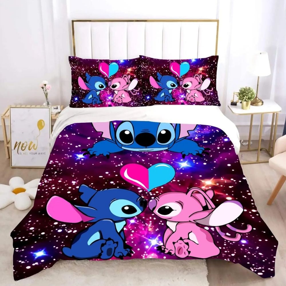 Parure de lit Sitch et Angel amoureux face à face avec un coeur rose et bleu au-dessus d'eux. Le fond ressemble à un ciel étoilé. Deux coussins assortis à la housse de couette se trouvent en haut du lit. Une table de chevet de chaque côté blanche et beige.