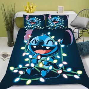 Parure de lit Stitch originale bleu marine avec Stitch souriant enroulé dans une guirlande lumineuse. Deux coussins sont assortis. Sur un lit double avec une tête de lit blanche, une chaise en métal sur la droite et de la verdure à gauche dans un vase.