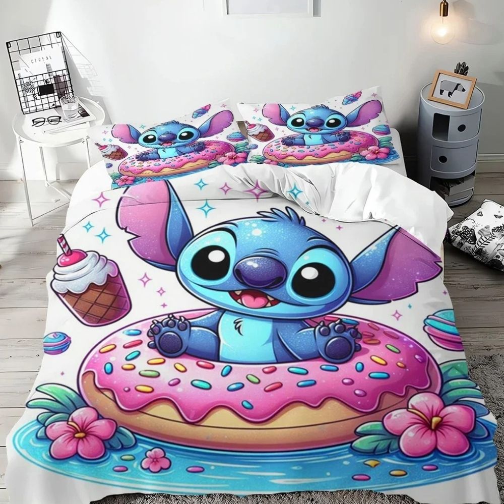Parure de lit adorable de Stitch avec une corne de licorne sur un arc-en-ciel avec deux nuages aux extrémités. Le tout sur fond blanc. Sur un lit double avec deux coussins assortis avec le même design.