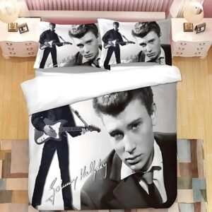 Parure de lit Johnny Hallyday en noir et blanc de l'artiste jeune en costume sur la droite et avec une guitare sur la gauche. Les deux coussins sont assortis à la housse de couette et sont tous posés sur un lit double.