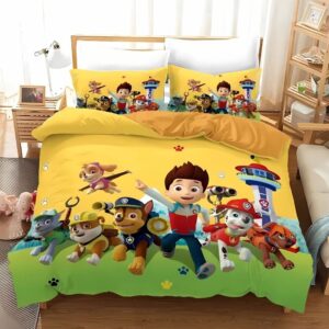 Parure de lit Pat'Patrouille avec l'équipe complète sur fond jaune avec de l'herbe sur lebas. Les deux coussins sont assortis à la housse de couette. Sur un lit double dans une chambre avec une grande fenêtre derrière.