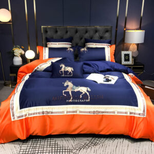 Parure de lit orange à motif cheval élégant avec le contour orange et le centre bleu marine. Sur un lit avec une tête de lit capitonnée noire.