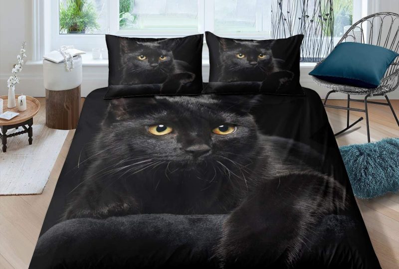 Parure de lit représentant un chat noir aux yeux jaunes dans une chambre avec parquet et murs blancs dont une table basse noire et deux coussins bleus