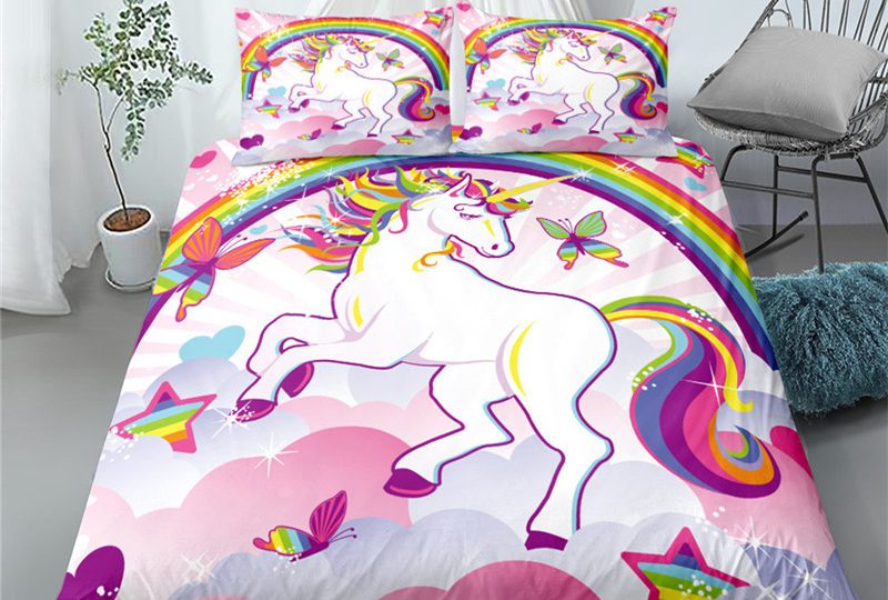 Parure représentant une licorne blanche à la crinière multicolore sous un arc-en-ciel entourée de papillons et d'étoiles multicolores dans les nuages