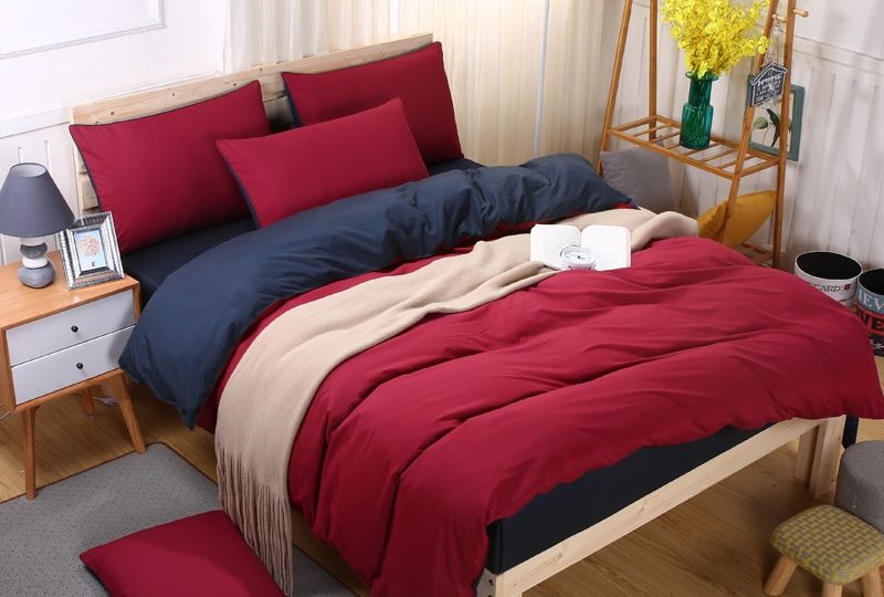Parure de lit rouge et bleu. Bonne qulaité, confortable et à la mode sur un lit dans une maison
