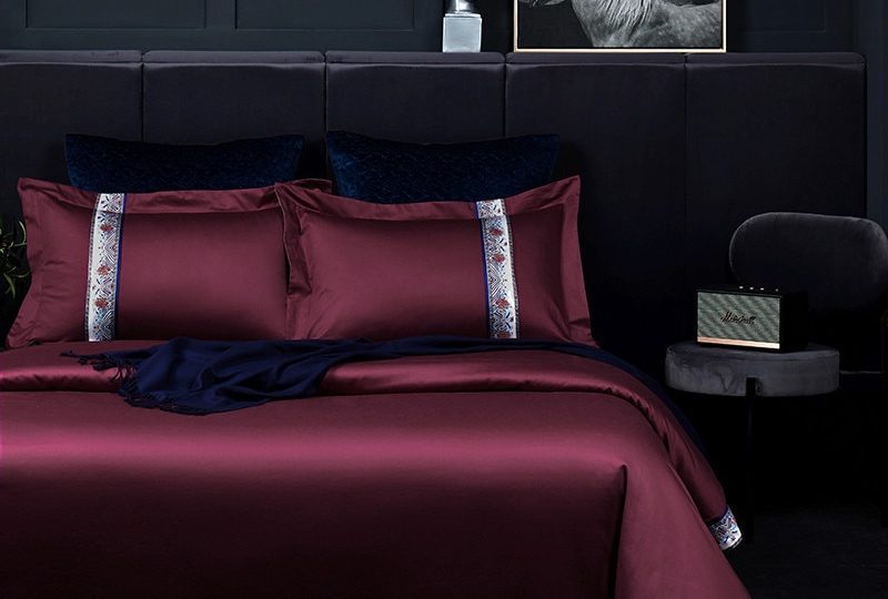 Parure de lit rouge foncé en coton égyptien. Bonne qualité, confortable et à la mode sur un lit dans une maison