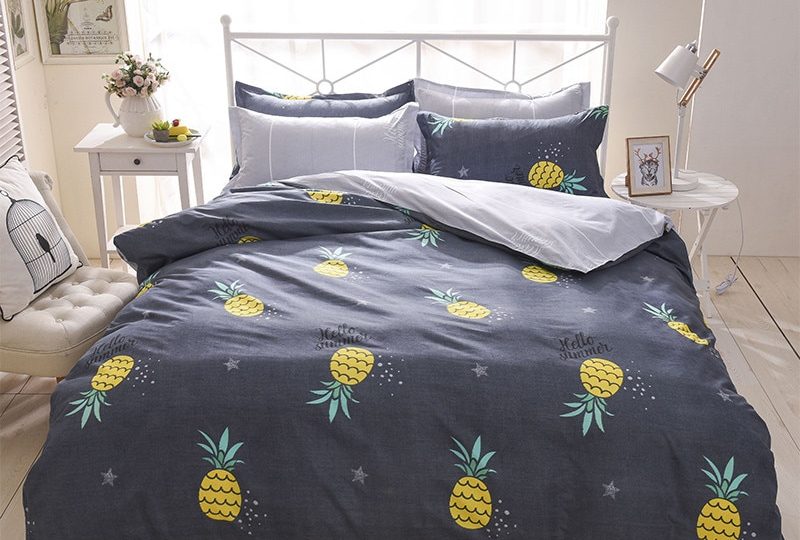 Parure de lit ananas noire. Bonne qualité, confortable et à la mode sur un lit dans une maison