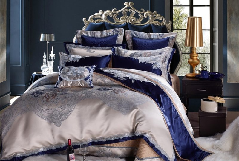 Parure de lit en satin bleu et doré. Bonne qualité, confortable et à la mode sur un lit dans une maison