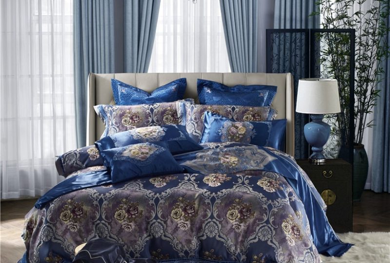 Parure de lit satin bleu avec motif fleurs. Bonne qualité, confortable et à la mode sur un lit dans une maison