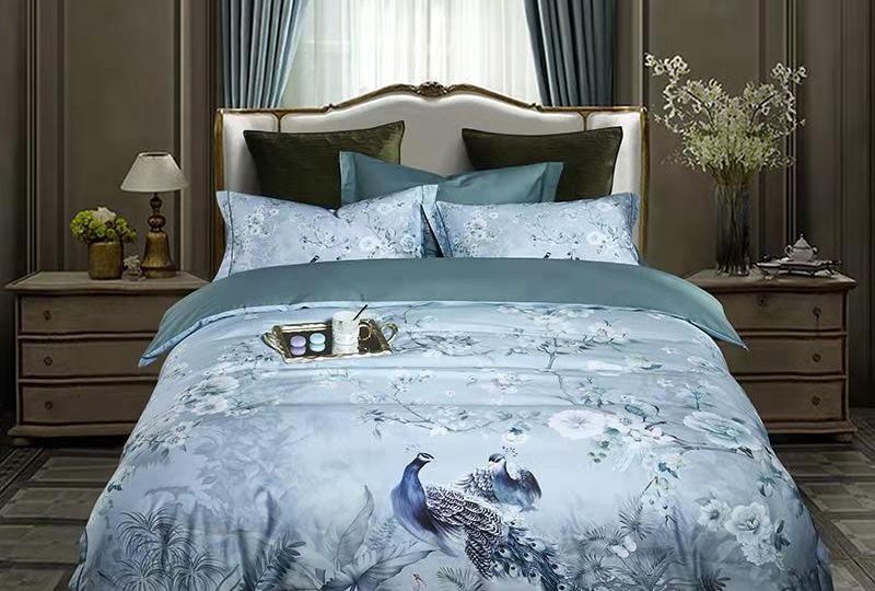 Parure de lit bleu motif paon. Bonne qualité, confortable et à la mode sur un lit dans une maison