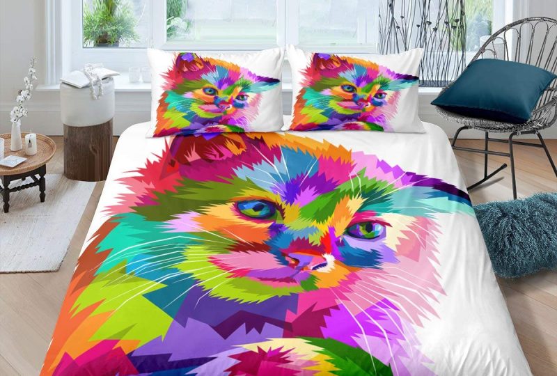 Parure de lit représentant un chat aux yeux bleus et au pelage multicolore sur un fond blanc dans une chambre avec parquet et mur blanc