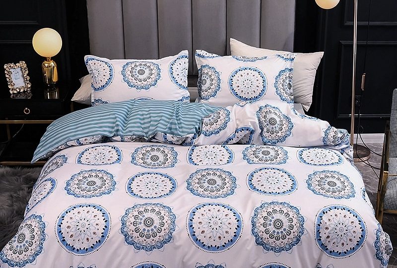 Parure de lit blanche motif mandala. Bonne qualité, confortable et à la mode sur un lit dans une maison