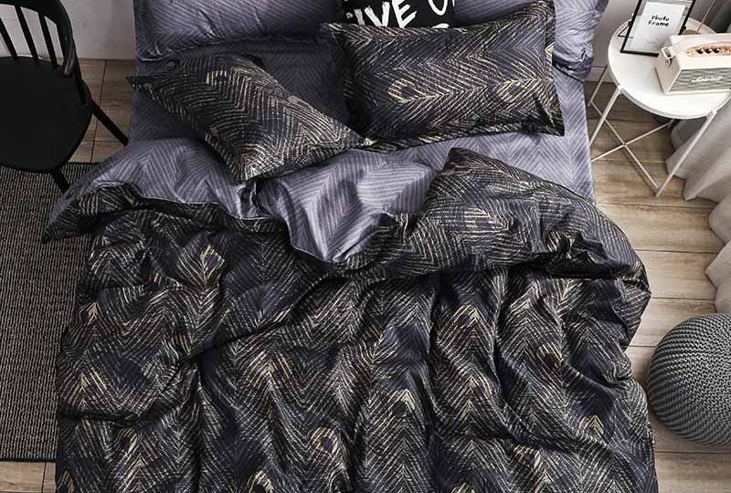 Parure de lit noir motif plume de paon. Bonne qualité, confortable et à la mode sur un lit dans une maison
