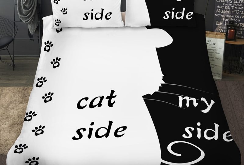 Parure de lit noir et blanc avec empreinte de chat. Bonne qualité, confortable et à la mode sur un lit dans une maison