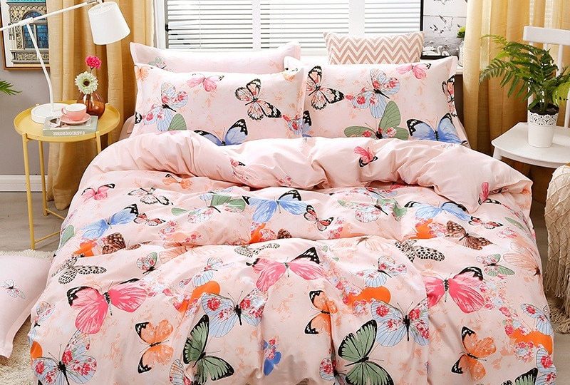 Parure de lit colorée papillons. Bonne qualité, confortable et à la mode sur un lit dans une maison