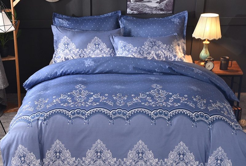 Parure de lit bleue dentelle florale. Bonne qualité, confortable et à la mode sur un lit dans une maison