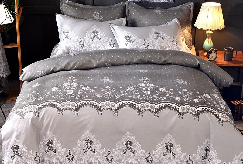 Parure de lit grise dentelle florale. Bonne qualité, confortable et à la mode sur un lit dans une maison