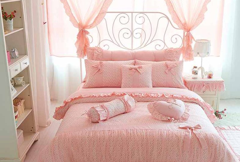 Parure de lit rose avec dentelle et motif nœud. Bonne qualité, confortable et à la mode sur un lit dans une maison