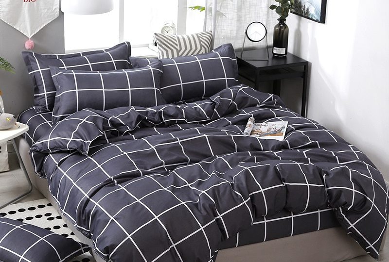 Parure de lit gris motifs à carreaux. Bonne qualité, confortable et à la mode sur un lit dans une maison