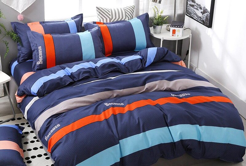 Parure de lit bleu marine à rayures multicolore. Bonne qualité, confortable et à la mode sur un lit dans une maison