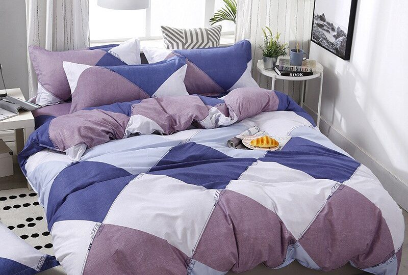 Parure de lit motifs géométriques tricolores. Bonne qualité, confortable et à la mode sur un lit dans une maison
