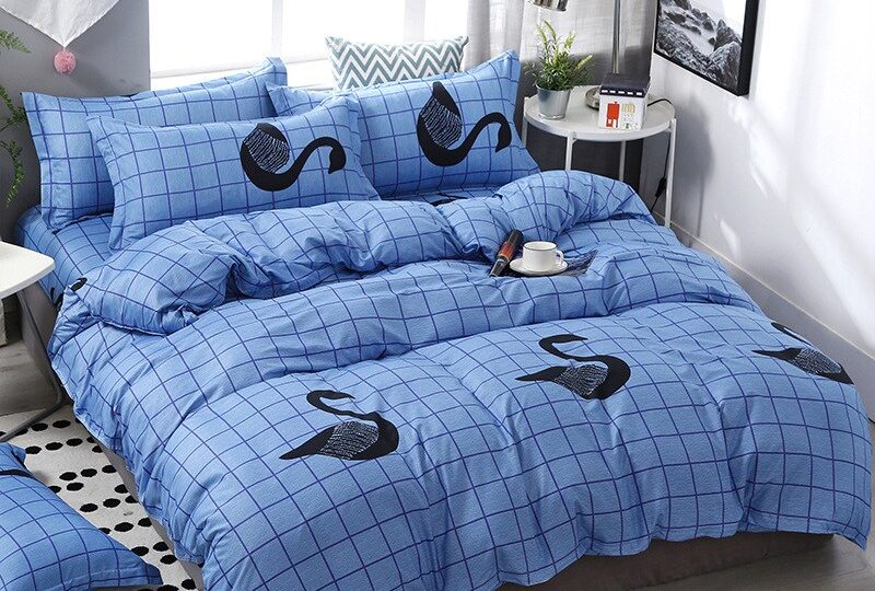 Parure de lit bleue motif cygne. Bonne qualité, confortable et à la mode sur un lit dans une maison