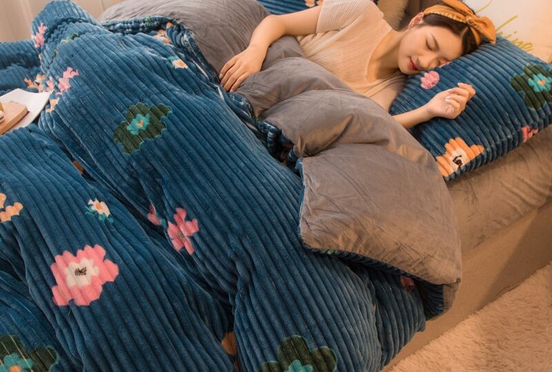 Parure de lit bleu marine motif fleurs. Bonne qualité, confortable et à la mode sur un lit dans une maison