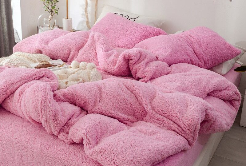 Parure de lit rose effet fourrure. Bonne qualité, confortable et à la mode sur un lit dans une maison